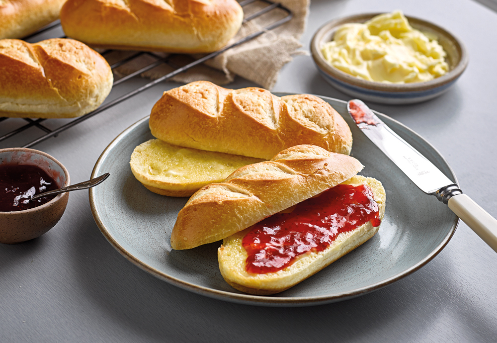 Two St Pierre Brioche Rolls sliced in half, with one filled with strawberry jam for a traditional Breakfast - Easy ways switch brioche